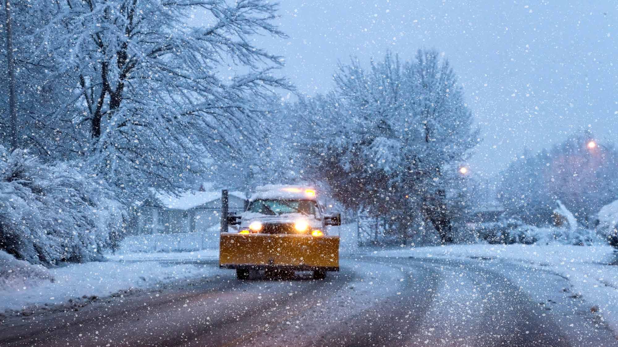 Valley Landscape Service plow truck clearing a Jackson Hole driveway during a snowstorm